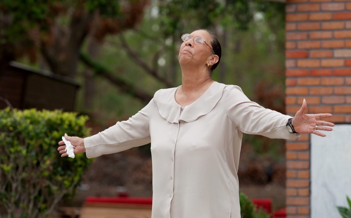 Ella Doyle lifts her head in prayer and tells fellow parishioners to “hold your head up” during an outdoor worship service at Hartzell Mt. Zion United Methodist Church in Slidell, La. The church's sanctuary was ruined by the Aug. 29 storm surge from Hurricane Katrina. Doyle rode out the storm in a boat with her husband and two sons. A UMNS photo by Mike DuBose. Ella Doyle lifts her head in prayer and tells fellow parishioners to “hold your head up” during an outdoor worship service at Hartzell Mt. Zion United Methodist Church in Slidell, La. The church's sanctuary was ruined by the Aug. 29 storm surge from Hurricane Katrina. Doyle rode out the storm in a boat with her husband and two sons. A UMNS photo by Mike DuBose.