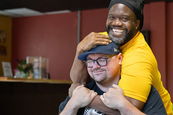 Timothy "GA" Underwood hugs the Rev. Dustin Mailman in the recently opened coffee shop of the Deep Time ministry in Asheville, N.C. Underwood serves as minister of social enterprise for Deep Time and Mailman is its founding pastor. The program, which seeks to create a spiritual community with people impacted by incarceration, is housed at Trinity United Methodist Church in Asheville. Timothy "GA" Underwood hugs the Rev. Dustin Mailman in the recently opened coffee shop of the Deep Time ministry in Asheville, N.C. Underwood serves as minister of social enterprise for Deep Time and Mailman is its founding pastor. The program, which seeks to create a spiritual community with people impacted by incarceration, is housed at Trinity United Methodist Church in Asheville.