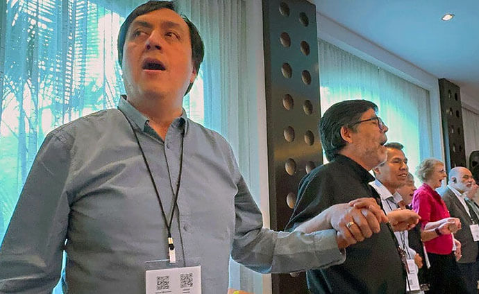 Consultation participants join in the song “Momento Novo” (New Moment) during the closing worship service of the mission gathering in Panama City. From left to right are Bishop César Llanco Zavaleta of the Methodist Church in Peru; Bishop Jorge Merino Riffo of the Methodist Church in Chile; Bishop Medardo Vedia Gutiérrez of the Evangelical Methodist Church in Bolivia; Bishop Américo Jara of the Evangelical Methodist Church in Argentina; Dr. Evelyn Wibmer, president of the Methodist Church in Uruguay, and Bishop Roberto Alves de Souza of the Methodist Church in Brazil.