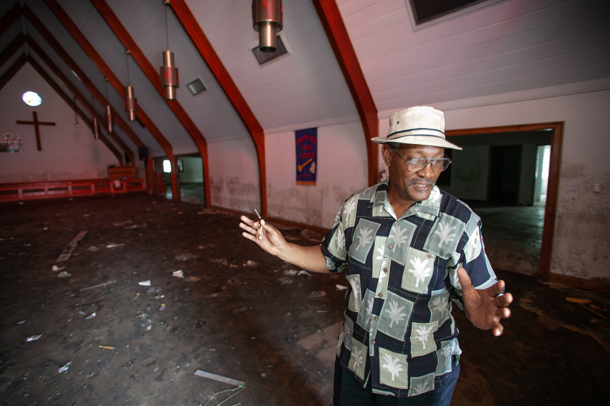 Anthony Alfred, a trustee at Hartzell Mt. Zion United Methodist Church, surveys flood damage to the sanctuary following Hurricane Katrina in 2005. The storm left six feet of water in the sanctuary.