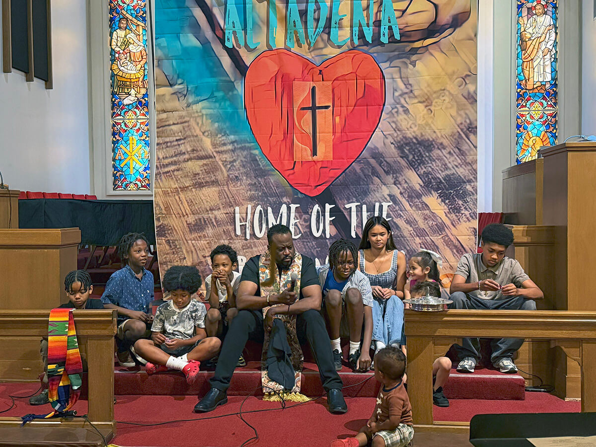 The Rev. J. Andre Wilson (center) shares a message with children during Altadena United Methodist Church’s first Sunday worship service at its new temporary home on the campus of the former First United Methodist Church of San Gabriel, Calif. Altadena is one of two United Methodist churches destroyed by wildfires in January. Photo courtesy of Heather Wilson.