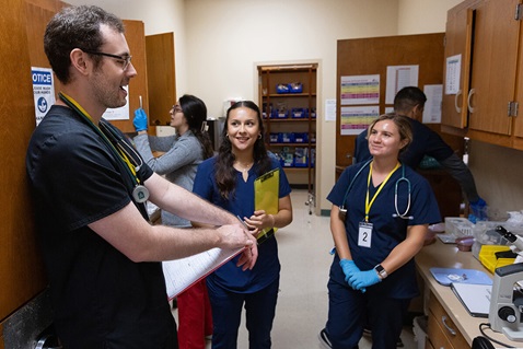 Medical students work in the lab at Luke’s House, a free health clinic in New Orleans. From left, with faces visible, are Ryan Barry, Zahra Naeini, Karla Gallegos Díaz and Amelie Jacobs. A United Methodist pastor helped start the clinic in 2006 in response to the health care gap left by Hurricane Katrina. Photo by Mike DuBose, UM News.