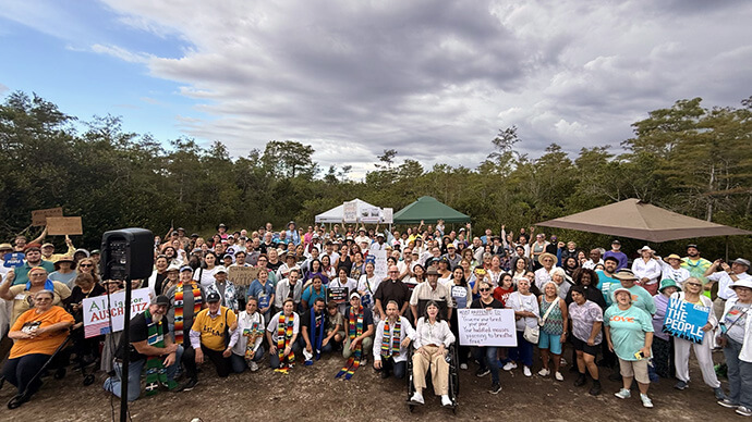 The Rev. Andy Oliver (front row center) poses with fellow protestors outside the detention center known as “Alligator Alcatraz” in the Everglades, where demonstrations are happening once a week in support of the undocumented people being held there. Photo courtesy the Rev. Andy Oliver.