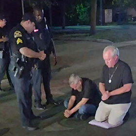 The Rev. Andy Oliver (sitting at center) protests the removal of a Black History Matters mural on a street near the Woodson African American Museum of Florida in St. Petersburg, Fla. Fellow protester Benedict Atherton-Zeman (right), minister at the Unitarian Universalist Church of St. Petersburg, was arrested along with Oliver and charged with misdemeanor obstruction. They could be sentenced to a year in jail if convicted. Photo courtesy of the Rev. Andy Oliver.