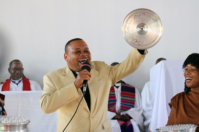 The Rev. Americo Levi Vilanculos, one of the church’s founding pastors, gives a communion set as a gift to the congregation of Muhalaze United Methodist Church. “I am happy to have been part of starting a new community, and to realize the dream has really come true,” he said. Photo by Roque Facela, UM News.