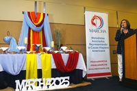 Emma Escobar, president of MARCHA (Associated Methodists for the Hispanic-Latino American Cause), speaks during the opening ceremony of the caucus’ 53rd annual assembly Aug. 1 in Chicago. The altar, prepared by the Spanish-Latino Ministries of the Northern Illinois Conference, offered a display of sacramental elements and colors as a liturgical expression of the diversity of races, cultures, theological interpretations, ages and genders that make up MARCHA. Photo by the Rev. Gustavo Vasquez, UM News. Emma Escobar, president of MARCHA (Associated Methodists for the Hispanic-Latino American Cause), speaks during the opening ceremony of the caucus’ 53rd annual assembly Aug. 1 in Chicago. The altar, prepared by the Spanish-Latino Ministries of the Northern Illinois Conference, offered a display of sacramental elements and colors as a liturgical expression of the diversity of races, cultures, theological interpretations, ages and genders that make up MARCHA. Photo by the Rev. Gustavo Vasquez, UM News.