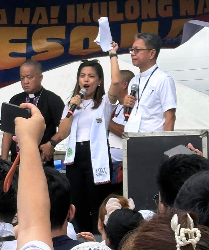 Deaconess Blessy Grace De Leon (center), director of communications for The United Methodist Church’s Manila Episcopal Area, acts as moderator as religious leaders from different faiths speak before a massive crowd gathered in Quezon City to protest government corruption in the Philippines. Photo courtesy of Blessy Grace De Leon.