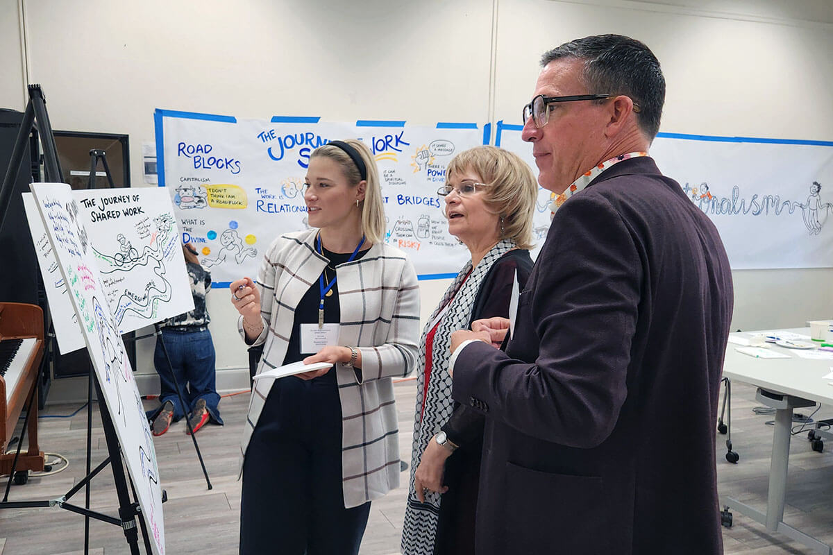 Sarah Metroff (à gauche), responsable marketing des investissements chez Wespath Benefits and Investments, s'entretient avec M. Theresa Basile (au centre), cofondatrice de United Methodists for Kairos Response, et Andy Hendren (à droite), directeur général de Wespath, lors des réunions de septembre au Garrett-Evangelical Theological Seminary à Evanston, dans l'Illinois. Wespath a organisé ce sommet afin de favoriser le dialogue sur ses investissements. Photo gracieusement fournie par Wespath Benefits and Investments. 