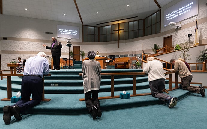 Parishioners and guests respond to an altar call issued by Bishop Frank Beard (background) at Elkhart Faith United Methodist Church. Photo by Mike DuBose, UM News.