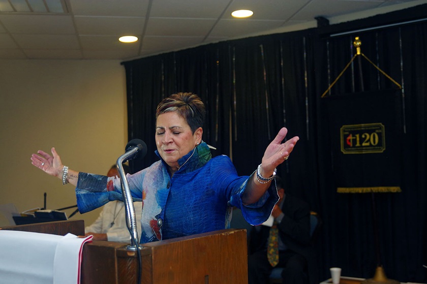 La Obispa Cynthia Fierro Harvey dirige una oración durante la celebración del 120mo aniversario de la IMU La Trinidad en mayo de 2025. Fiero Harvey  líder episcopal de las conferencias anuales de Texas y Rio-Tejas, recibió un reconocimiento de la iglesia por su labor episcopal y el apoyo que siempre a brindado a la congregación y su conferencia. Fierro Harvey dijo que “esta congregación es un símbolo de lucha, fidelidad y resistencia”. Foto Rev. Gustavo Vasquez, noticias MU.