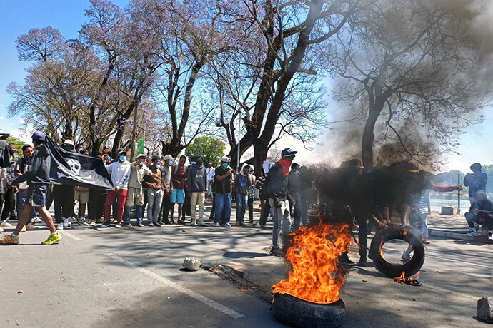 University students and unemployed youth protest in the streets as tires burn in Antananarivo, Madagascar. The Oct. 10 demonstration followed earlier clashes between security forces and protesters voicing their frustrations over social and economic conditions in the country. Photo by Rakotoarivony Esdras, UM News.