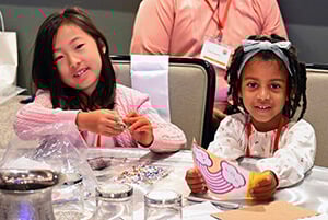 Jaynie Lim (à gauche) et Jeymiah Brown (à droite) réalisent un projet d'artisanat pendant que leurs parents, membres du clergé Méthodiste Uni, participent à la conférence Facing the Future 2025 à Los Angeles. Photo de Jim Patterson, UM News.