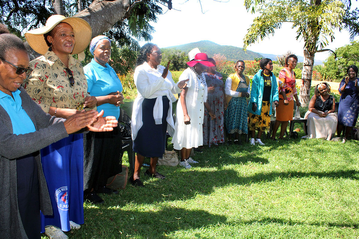 Les membres de Women of  Substance chantent lors d'un programme de prière en montagne au jardin botanique Ewanrigg à Harare, au Zimbabwe. Le groupe est composé de femmes célibataires, divorcées ou veuves, membres de l'Église, qui participent à des formations sur des projets générateurs de revenus, à des retraites de prière et à d'autres excursions. Photo de Kudzai Chingwe, UM News.