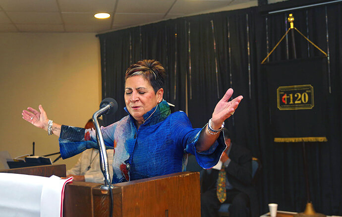 Bishop Cynthia Fierro Harvey leads a prayer during the 120th anniversary celebration of La Trinidad United Methodist Church in May. The church recognized her for her work as the leader of the Texas and Rio Texas annual conferences and for her support of the congregation. The bishop said that “this congregation is a symbol of struggle, faithfulness and resilience.” Photo by the Rev. Gustavo Vasquez, UM News.