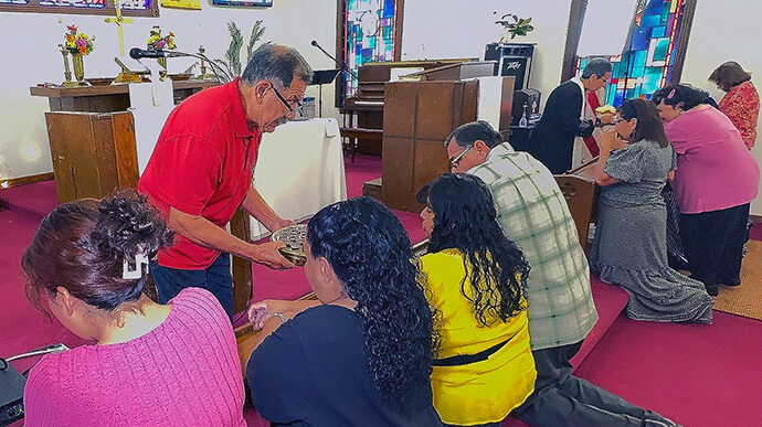 The Rev. Rudy Herrera has served as leader and associate pastor at La Trinidad United Methodist Church, administering communion alongside the Rev. Nohemí Ramírez. Photo by the Rev. Gustavo Vasquez, UM News.