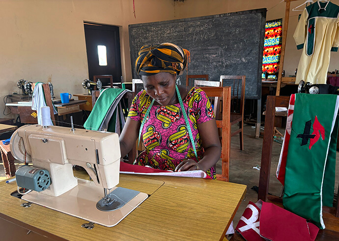 Fredienne Haganzimana, a trainer at the United Methodist Women’s Center at Nyabugogo United Methodist Church in Gitega, Burundi, sews clerical attire that is sold to support the center’s running costs.  The center trains members from the local community to sew clothes, school uniforms and clergy apparel. Photo by Eveline Chikwanah, UM News.