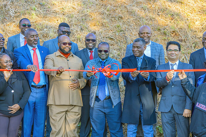 Le Révérend Alfiado Zunguza, Président sortant du Conseil d'Administration de l'Africa University, coupe le ruban lors de l'inauguration de la centrale solaire de l'Africa University à Mutare, au Zimbabwe, le 6 juin, sous le regard des dignitaires de l'église et de l'école. La centrale, d'un coût de 400 000 dollars, a été entièrement financée par Africa University Tennessee Inc., permettant ainsi à l'Université d'atteindre l'un de ses objectifs stratégiques pour 2025. Photo prise par le bureau des relations publiques de l'Africa University.