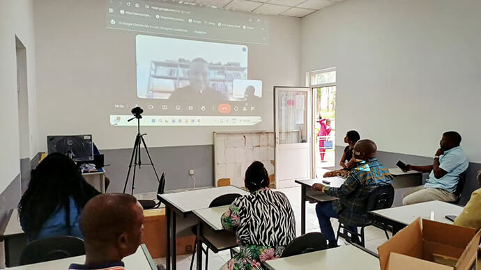 Sua Reverendíssima Bispo Moisés Bernardo Jungo (sentado na segunda fila à direita),  Rev.Manuel Calimb ue, professora CleivyRivalta, e Rev. Victorino de Almeida assistem ao teste de aula virtual no Instituto Compartilhado Metodista no Quéssua, Malanje, Angola. Foto de João Nhanga, Notícias da MU.