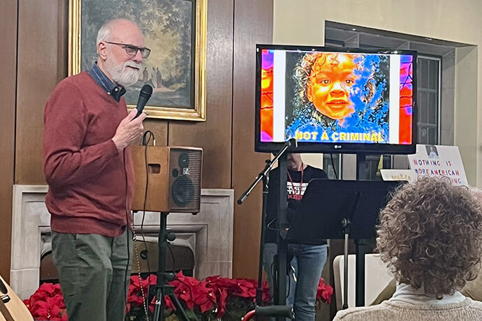 Photographer Bill Franz speaks at Dearborn First United Methodist Church near Detroit on Dec. 4 during “A Night of Art and Protest: Immigration.” He discusses his photographs of undocumented immigrant children, each one captioned “Not a Criminal.” Photo courtesy of Dearborn First United Methodist Church.