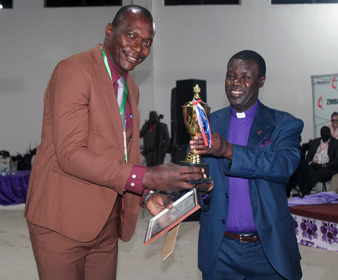 Pastor Zondai Chifamba (left) receives an award from Bishop Gift K. Machinga, who oversees the Zimbabwe, Zambia, Malawi and Botswana Episcopal Area. Chifamba was recognized during the Zimbabwe East Annual Conference meeting on Oct. 25 for his contributions in building a new sanctuary in the Gudyanga Birchenough Circuit. “When everyone else saw an impossible task, (he) saw an opportunity to trust God and get his hands literally dirty,” Machinga said. Photo by Kudzai Chingwe, UM News. 