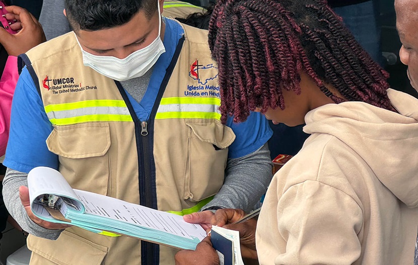 Yilmer Duarte (izquierda) miembro del personal de la clínica metodista unida, atendiendo a una de las migrantes que buscan servicios de salud en el Centro de Atención al Migrante Irregular (CAMI) de Danlí, Honduras. Foto Rev. Gustavo Vasquez, Noticias MU