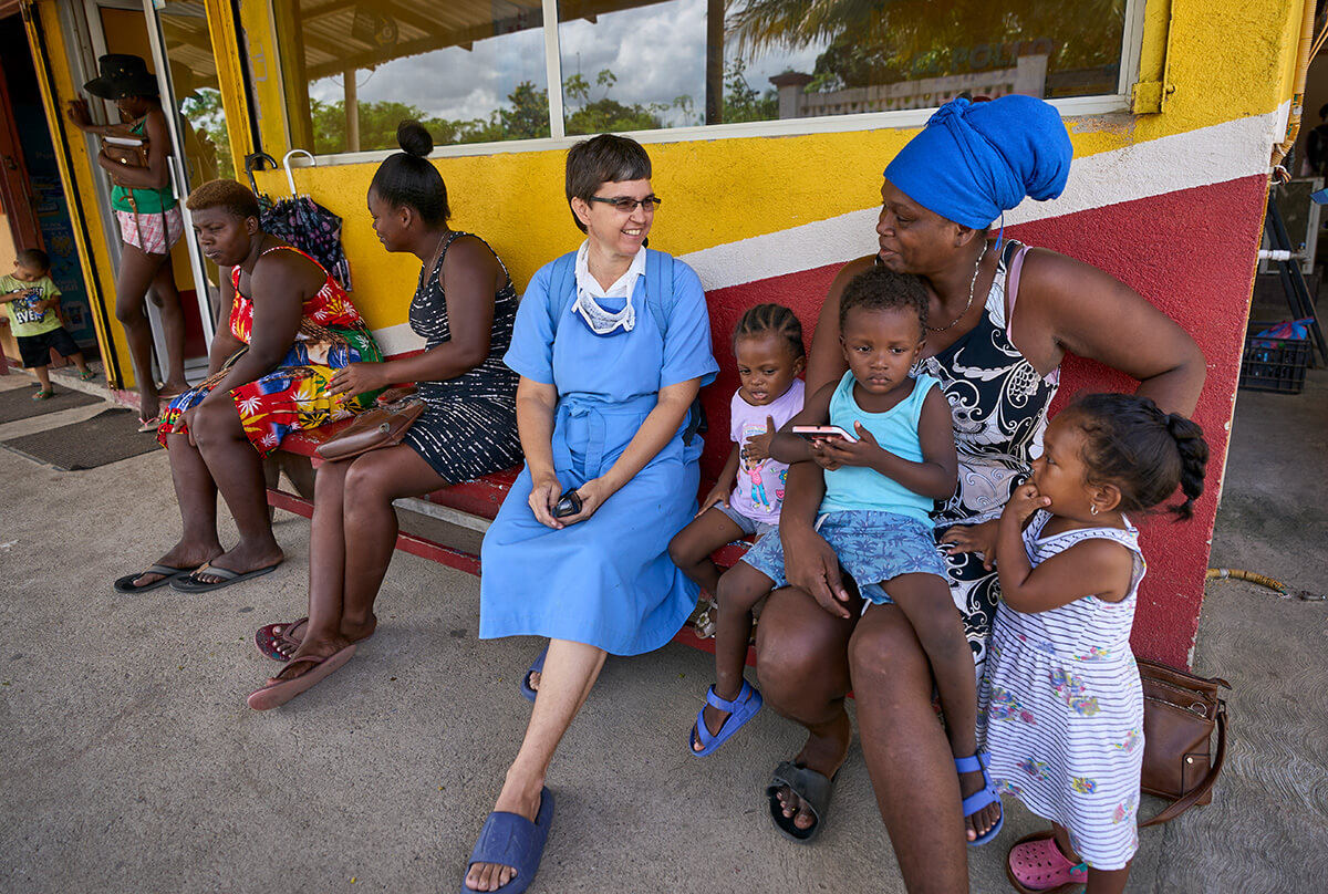 Sister Confianza (center) chats with her neighbors outside a store in Limón, Honduras. Photo by Paul Jeffrey, UM News.