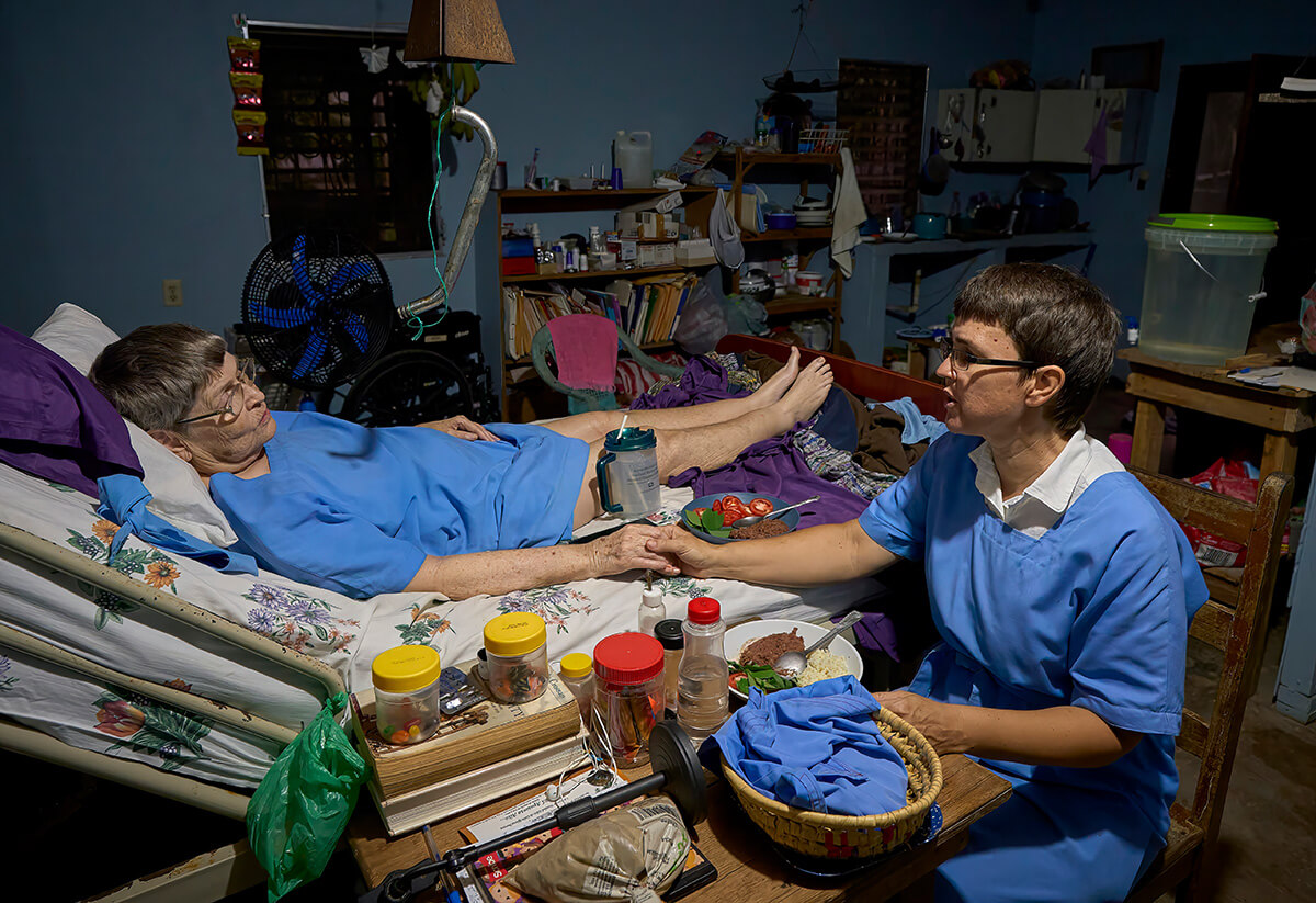 Sister Alegria (left) and Sister Confianza pray before a meal in their home. Photo by Paul Jeffrey, UM News.
