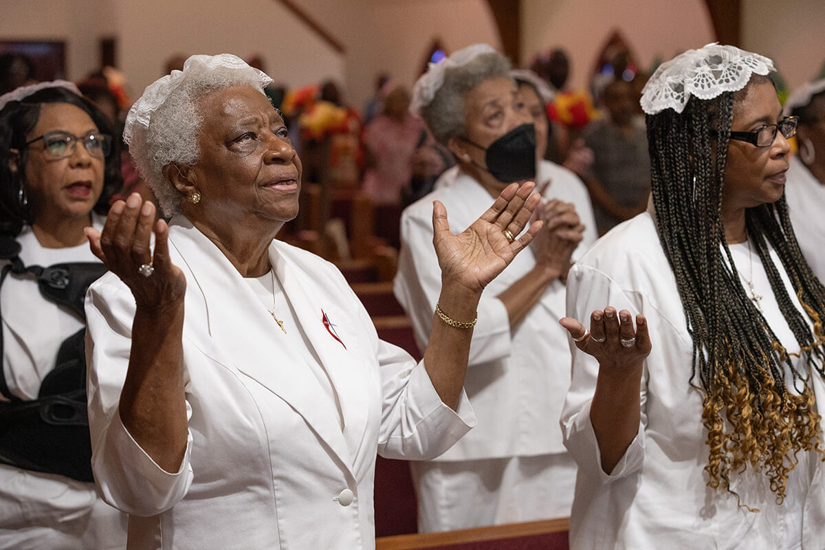 Atha Brown (left, front) joins with other communion stewards in praise during worship at Hartzell Mt. Zion United Methodist Church in Slidell, La., some 20 years after Hurricane Katrina flooded the sanctuary. Photo by Mike DuBose, UM News.
