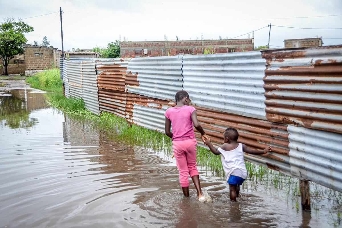 Children wade through floodwaters in a neighborhood in Maputo, Mozambique, on Jan. 16. Since the start of the rainy season in southern Africa, more than 100 people have died and hundreds of thousands have been displaced because of widespread flooding. United Methodists in the region are helping with relief efforts. (AP Photo/Carlos Uqueio)