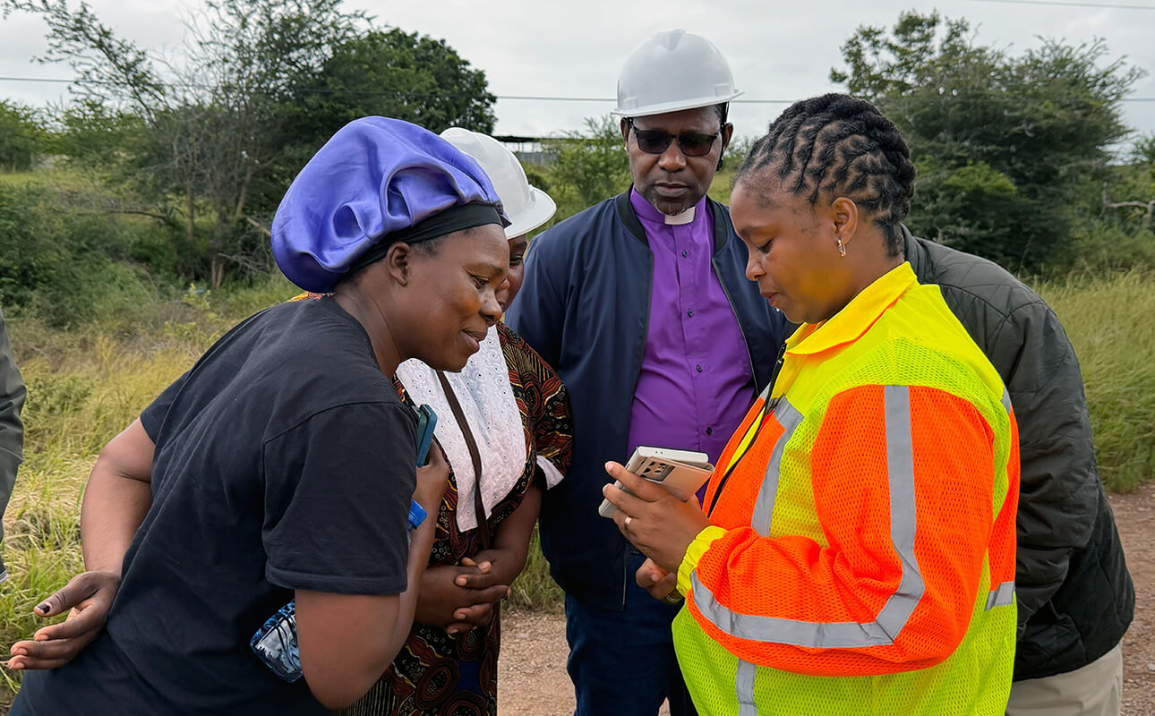 Geraldina Sarifa Francisco Utchavo Bonifácio (right), mayor of Boane District in Maputo, Mozambique, displays information on critical flooding areas for United Methodist Bishop João Filimone Sambo (center) and a church delegation. The group, which included the Rev. Victória Armando Chifeche, Maputo Province District superintendent, and Sansão Maculuve, Mozambique Conference lay leader, spent a day visiting affected areas. Photo by Roque Facela, UM News.