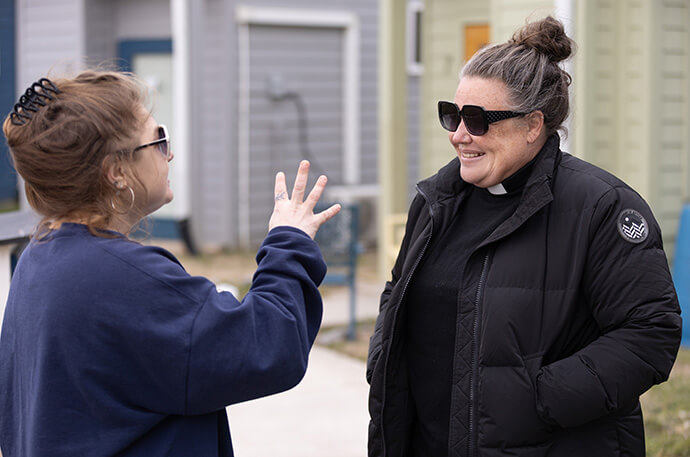 The Rev. Ingrid McIntyre (right) visits with Heather Heffner at the Village at Glencliff a ministry of Glencliff United Methodist Church in Nashville, Tenn. McIntyre is the church’s lead pastor and Heffner is program coordinator for the medical respite program housed on church property. Photo by Mike DuBose, UM News.
