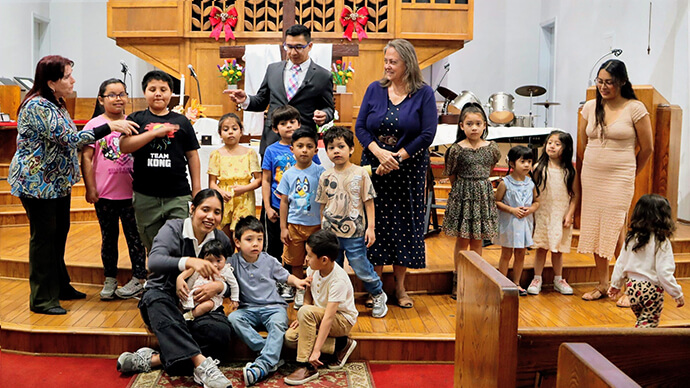 California-Pacific Conference Bishop Dottie Escobedo-Frank (in blue dress) visits with members of North Hills Hispanic Mission United Methodist Church in Los Angeles on Feb. 8. Church members say they were traumatized Jan. 29 when U.S. Immigration and Customs Enforcement swarmed church grounds to capture church member Carlos Chavez, who is an undocumented immigrant. Photo courtesy of North Hills Hispanic Mission United Methodist Church.   