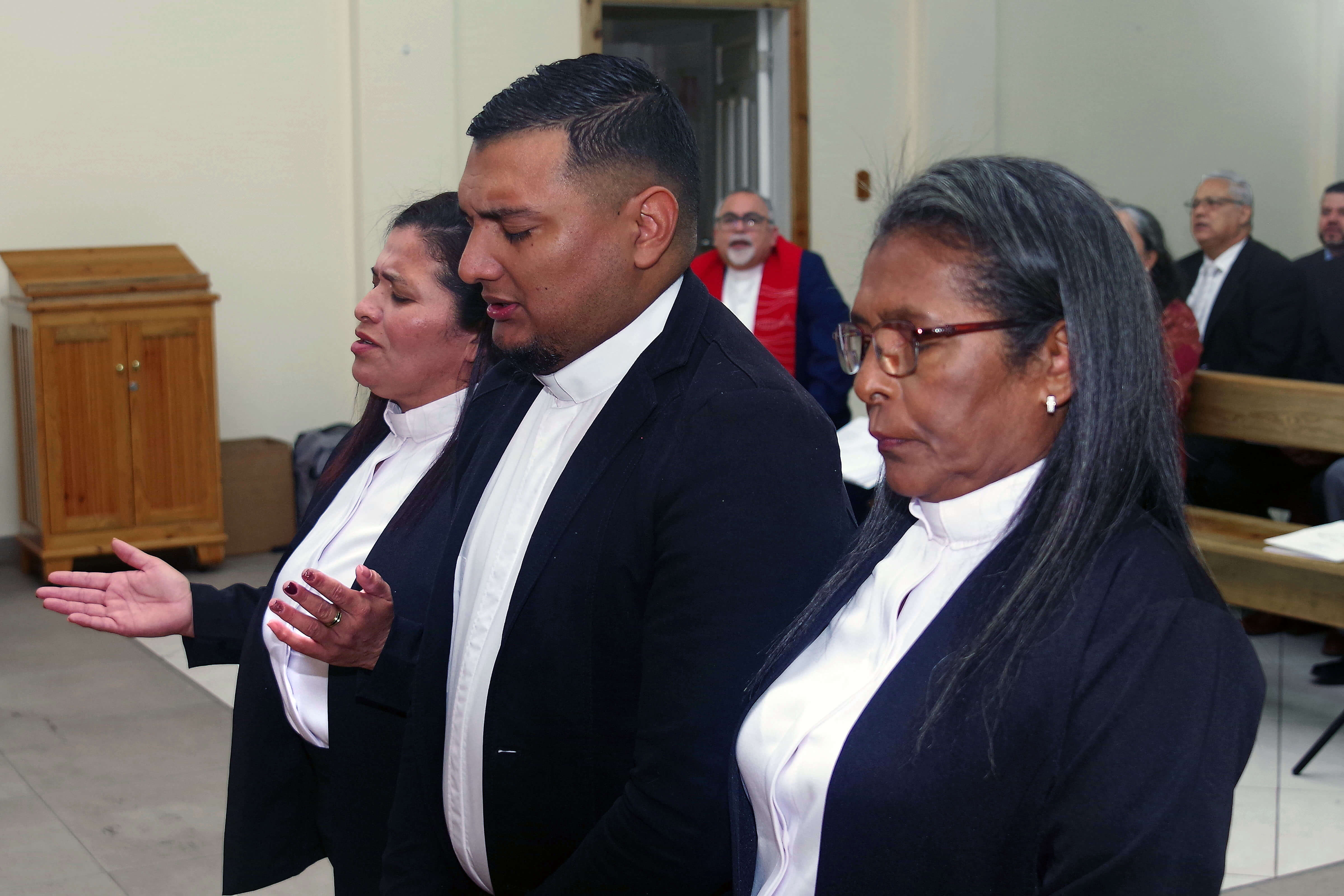 (From left:) Pastors Juana Jamileth Moncada Torres, Héctor Mauricio Rodríguez Laínez and María Magdalena Zelaya Cruz pray moments before being ordained during the closing service of the sixth annual meeting of the United Methodist Mission of Honduras. Photo by the Rev. Gustavo Vásquez, UM News.