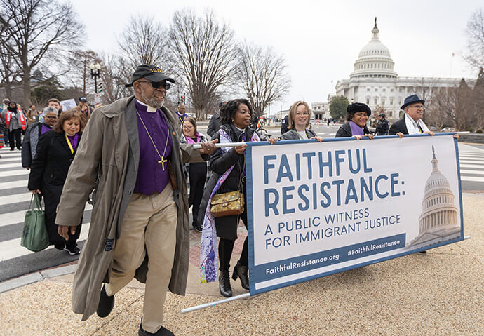 United Methodist Bishops Alfred Johnson (left) and Cynthia Moore-Koikoi hold the left side of the banner as participants in “Faithful Resistance: A Public Witness for Immigrant Justice” walk past the U.S. Capitol in Washington. Photo by Mike DuBose, UM News.