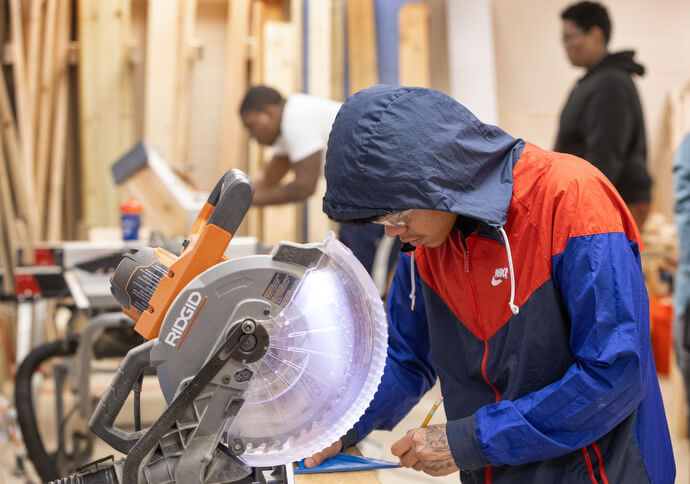 Jesús Orellana lines up a cut on the miter saw at the vocational training program of the Judge Dinkins Educational Center, housed at McKendree United Methodist Church in Nashville, Tenn. Photo by Mike DuBose, UM News.