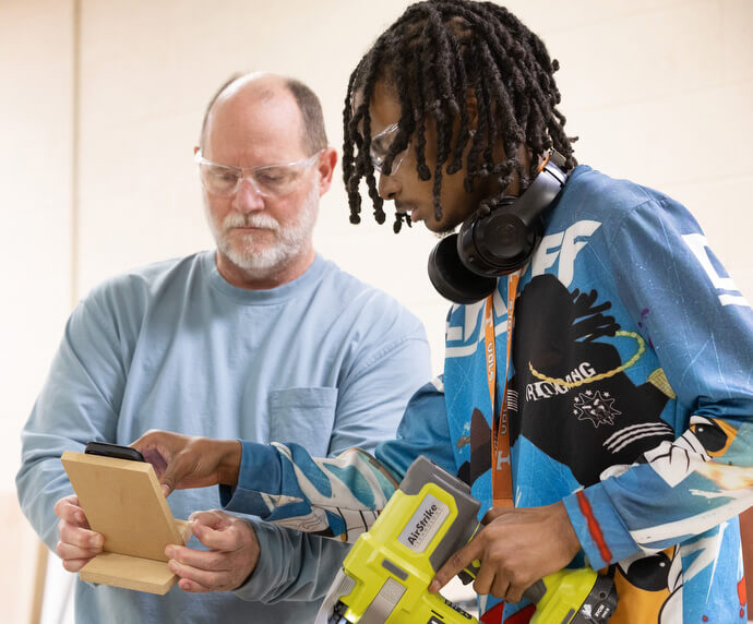 Vocational instructor Tim Queener (left) helps DeMarcus Wright build a phone charging stand in the Judge Dinkins Educational Center, housed at McKendree United Methodist Church in Nashville, Tenn. Photo by Mike DuBose, UM News.
