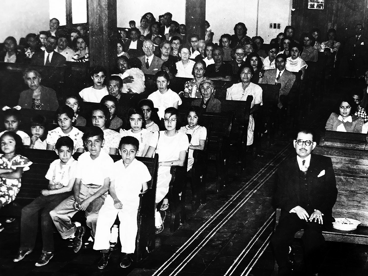 A young Raquel Martínez (second row, second seat from the aisle) attends worship at the Methodist Church in Saltillo, in the Mexican state of Coahuila, where her musical ministry began. “I liked to sit in the front pews because I was captivated by the sound of the organ and the choir singing,” she says. Her father, the Rev. Josué Mora (right), served as pastor. Photo courtesy of the Martínez family.