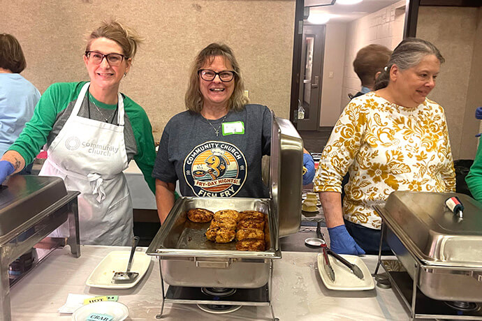 Volunteers work the fish-fry line at Community United Methodist Church in Irwin, Pa., on Feb. 27. In addition to Atlantic cod, the church’s 21-year, fish-fry ministry includes a serving of “secret recipe” crab cakes and a chicken tender option. Photo by Betsy Smith.
