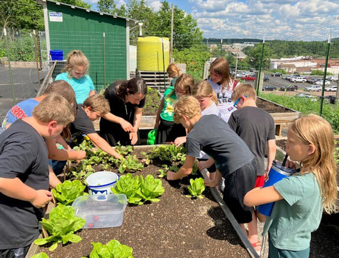 Children tend to a garden at Black River Falls United Methodist Church in rural Wisconsin. The congregation transformed an unused section of the church’s pavement into vegetable beds, producing more than 1,000 pounds of vegetables last year. Joe Williams of the church said, “The goal is to get neighbors involved. They help grow the vegetables, and then they can take them for free.” Photo courtesy of Joe Williams, Black River Falls United Methodist Church.