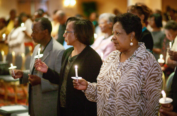 Participants in the first reunion of the former Central Jurisdiction of the Methodist Church light candles in memory of those from the jurisdiction who have gone before them during their 2004 meeting in College Park, Ga. The jurisdiction was a racially segregated structure for Black Methodists that existed from 1939 to 1968, when it was dissolved into the five current geographic jurisdictions of The United Methodist Church. From left are Earl Cleveland, Patricia White and Katie Harrison. File photo by Mike DuBose, UM News.Photo number 04-361, 9/1/04