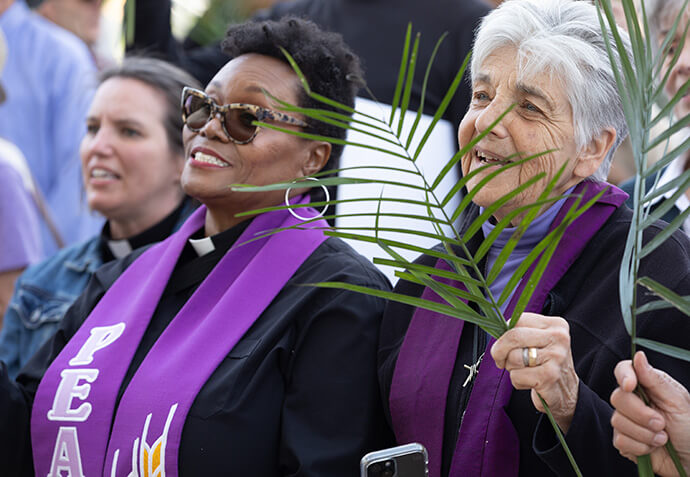 The Revs. Janet Wolf (right) and Amy E. Steele (center) sing during a Palm Sunday Witness in Nashville, Tenn. Wolf is an elder in The United Methodist Church and has served as a pastor of rural and urban congregations. Steele is director of the Wesley Foundation at Tennessee State University. 