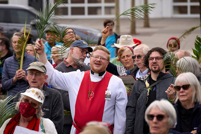 Le Révérend Ryan Scott (au centre), pasteur de la First United Methodist Church à Eugene, dans l’Oregon, agite une feuille de palmier lors de l’événement intitulé « Reclaiming Christianity in the Public Square: Standing Up and Speaking Out Against White Christian Nationalism » (Réaffirmer le christianisme dans l’espace public : se lever et s’élever contre le nationalisme chrétien blanc), le 29 mars. Cette célébration œcuménique faisait partie d’au moins 30 actions religieuses organisées à travers les États-Unis le dimanche des Rameaux. Photo de Paul Jeffrey, UM News.