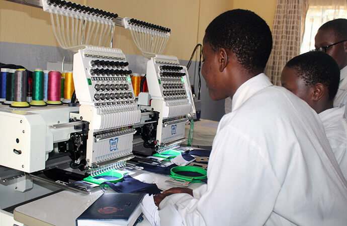 Students learn to operate the embroidery machine in the factory department at Murewa High School in Murewa, Zimbabwe. Under the watchful eye of instructor Memory Maibheka, teacher-in-charge, trainees can learn to operate any of the machines. Photo by Kudzai Chingwe, UM News.