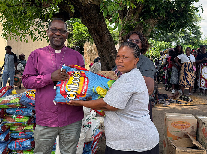 Bispo João Filimone Sambo, oferecendo productos alimentares à Pastoral Local Amélia Titos, uma das vítimas das inundações da Extensão Evangélica de Chibuto, na Província de Gaza. Photo by Roque Facela, Notícias MU.