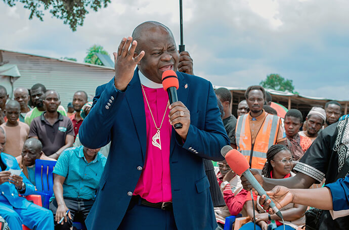 Bishop Mande Muyombo, president of the Africa Colleges of Bishops, speaks to refugees at the Musenyi camp in Burundi during a visit by a delegation from The United Methodist Church. In his message, he called on the warring parties in eastern Congo to make peace to end the cycle of human suffering that is forcing thousands of families into exile in Burundi. Photo courtesy of the communications department of the Burundi-Rwanda Episcopal Area.