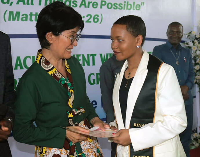 The Rev. Young Seon Christina Kim (left), founder of Global Mission Secondary School in Dar es Salaam, Tanzania, smiles as she presents a diploma to a graduate. Kim founded the school in 2021 with the vision that an education rooted in the Gospel could transform not only the students, but also their families and the community. Photo by Asaph Sungura Ally, UM News.