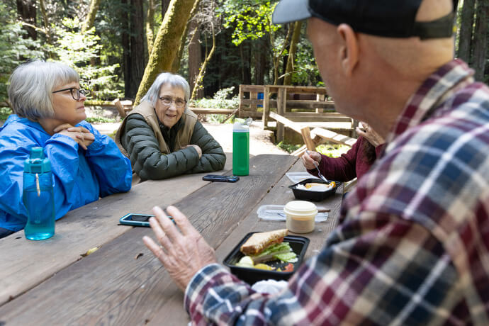 Chris Murray of Windsor Community United Methodist Church (right) visits with the Rev. Laurie Bayen and volunteer docent Joan Bacci during a lunch break at Armstrong Redwoods State Natural Reserve. 