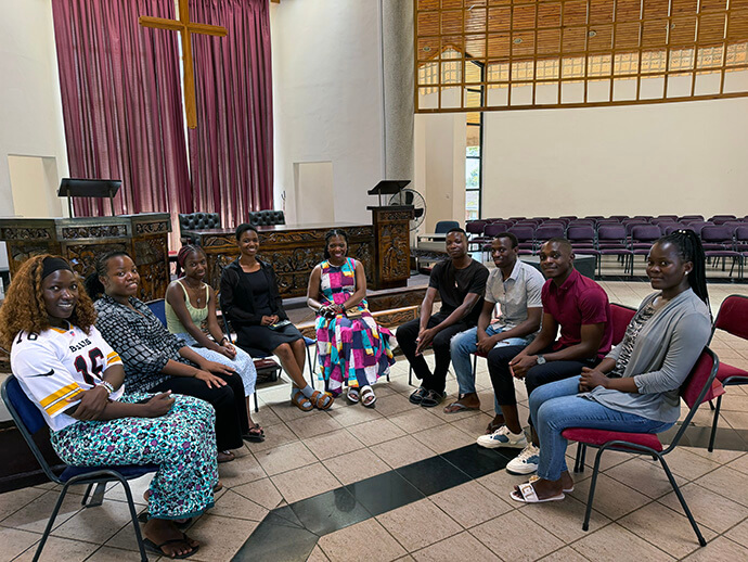 Monifa McKnight (center) meets with some of the African Methodist Episcopal students studying at Africa University.  McKnight, a lay member of the African Methodist Episcopal Church, is the first non-United Methodist to sit on the executive board of Africa University (Tennessee) Inc.  The meeting held in the Kwang Lim Chapel enabled McKnight to interact with  students who are members of her denomination. Photo courtesy of McKnight.
