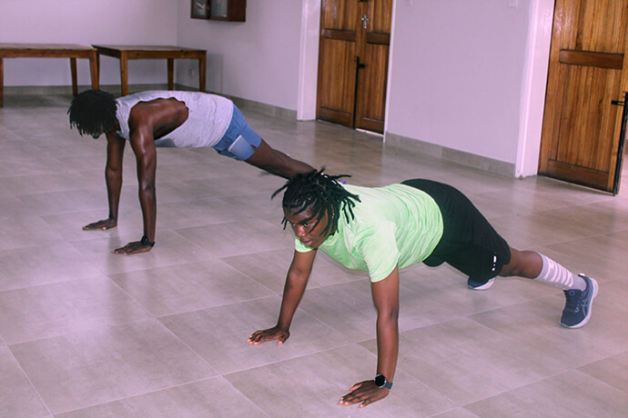 Anesu Vhumbunu (right) does pushups alongside Zumba instructor Elvis Mushawenyoka at Chisipiti United Methodist Church in Harare, Zimbabwe. Photo by Kudzai Chingwe, UM News.