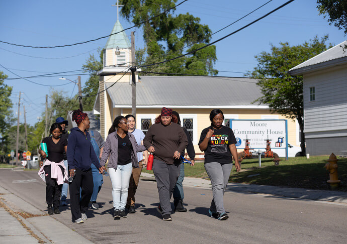 Students and staff of the Women in Construction training program walk past Moore Community House in Biloxi before classes begin. They start each day with a walk and calisthenics. The community house, founded in 1924, is a National Mission Institution of United Women in Faith.
